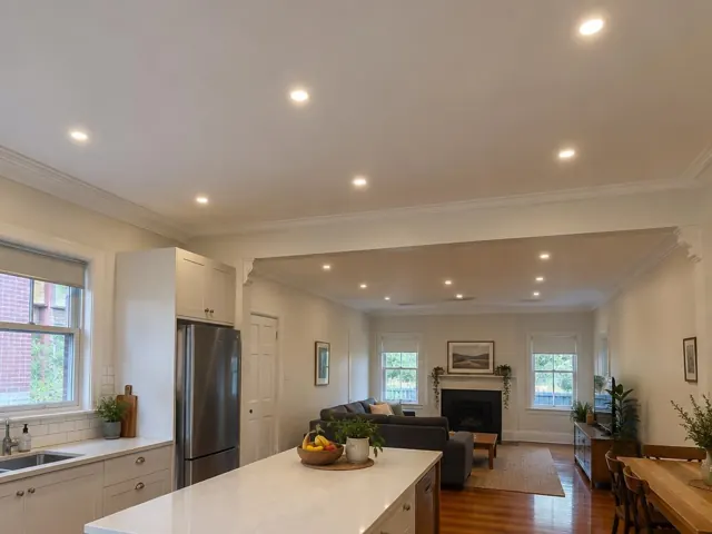 Modern open-plan kitchen and living room with recessed ceiling downlights and timber floors in Adamstown